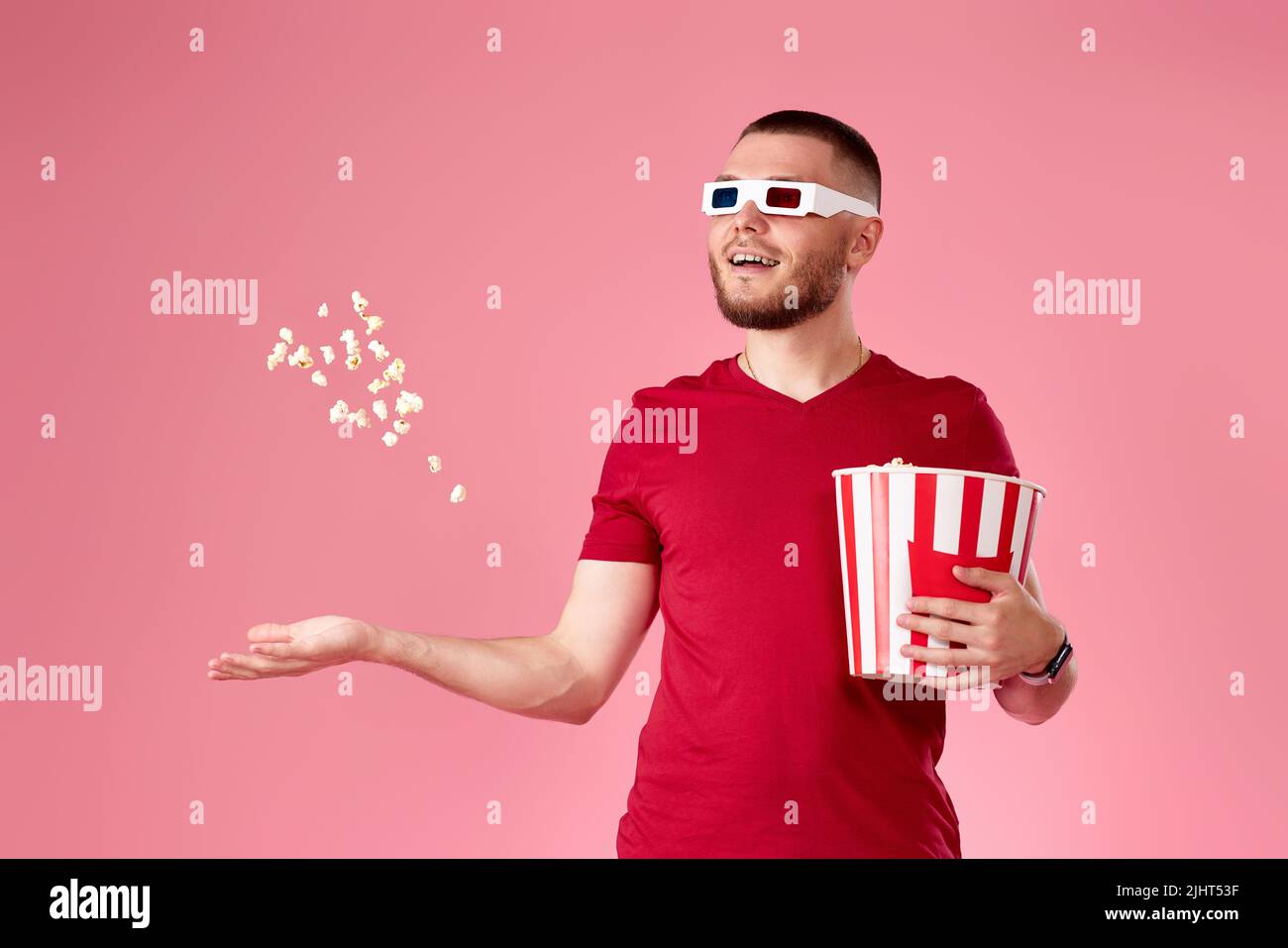 giovane uomo in 3d bicchieri gettando e mangiando popcorn Foto Stock