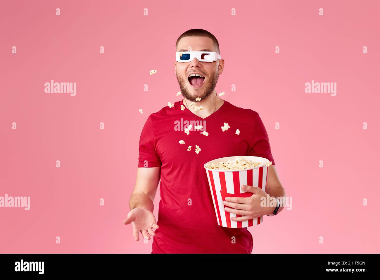 giovane uomo in 3d bicchieri gettando e mangiando popcorn Foto Stock