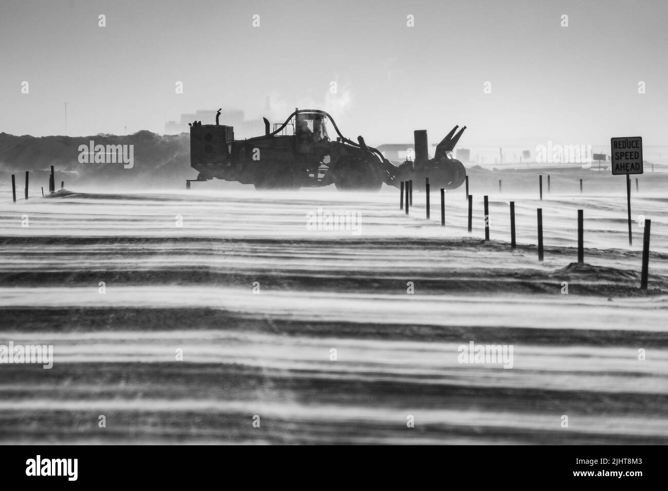 Una scala di grigi di un trattore che sgombrano la neve Foto Stock