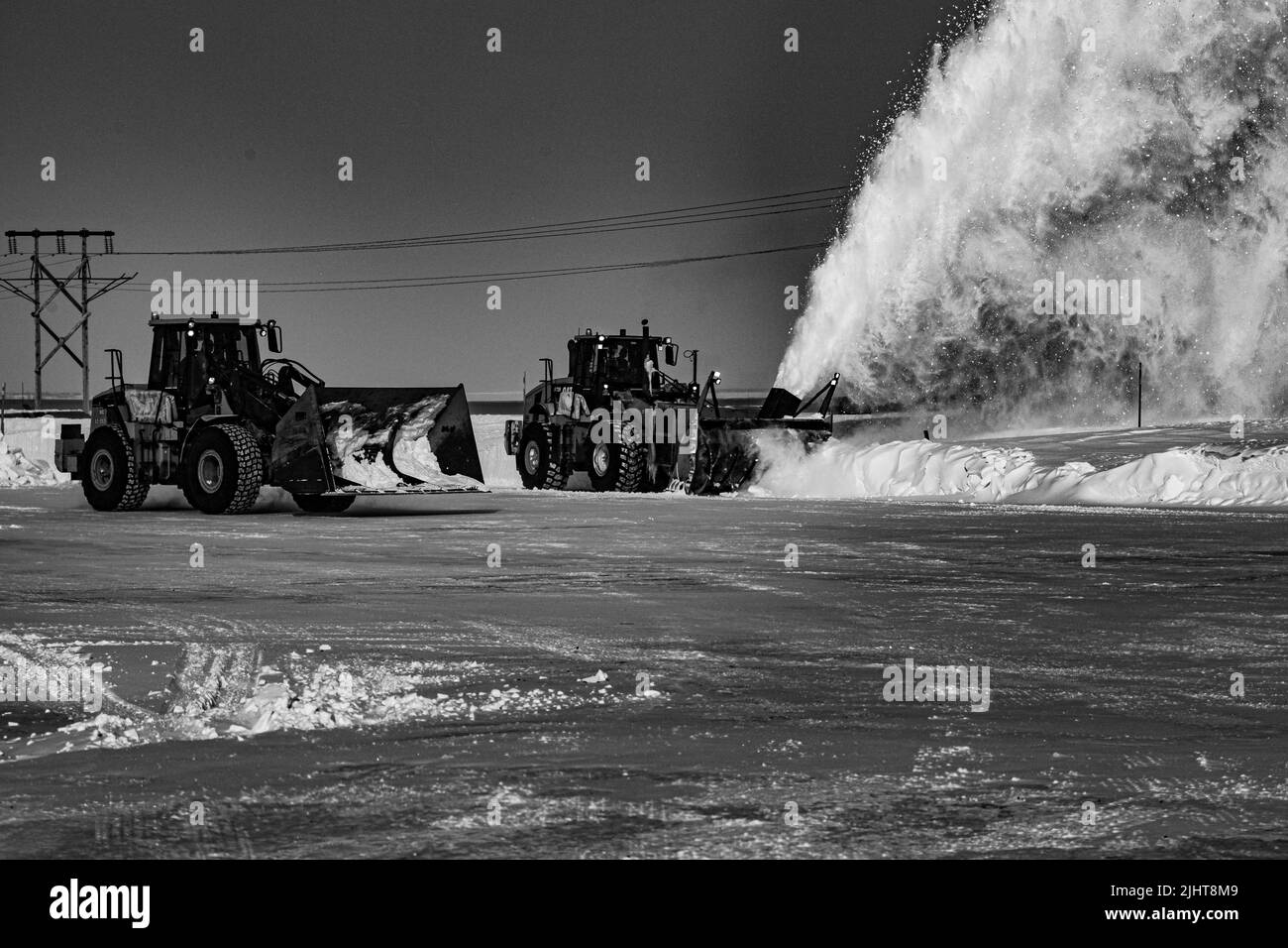 Una scala di grigi di trattori che sgombrano la neve Foto Stock