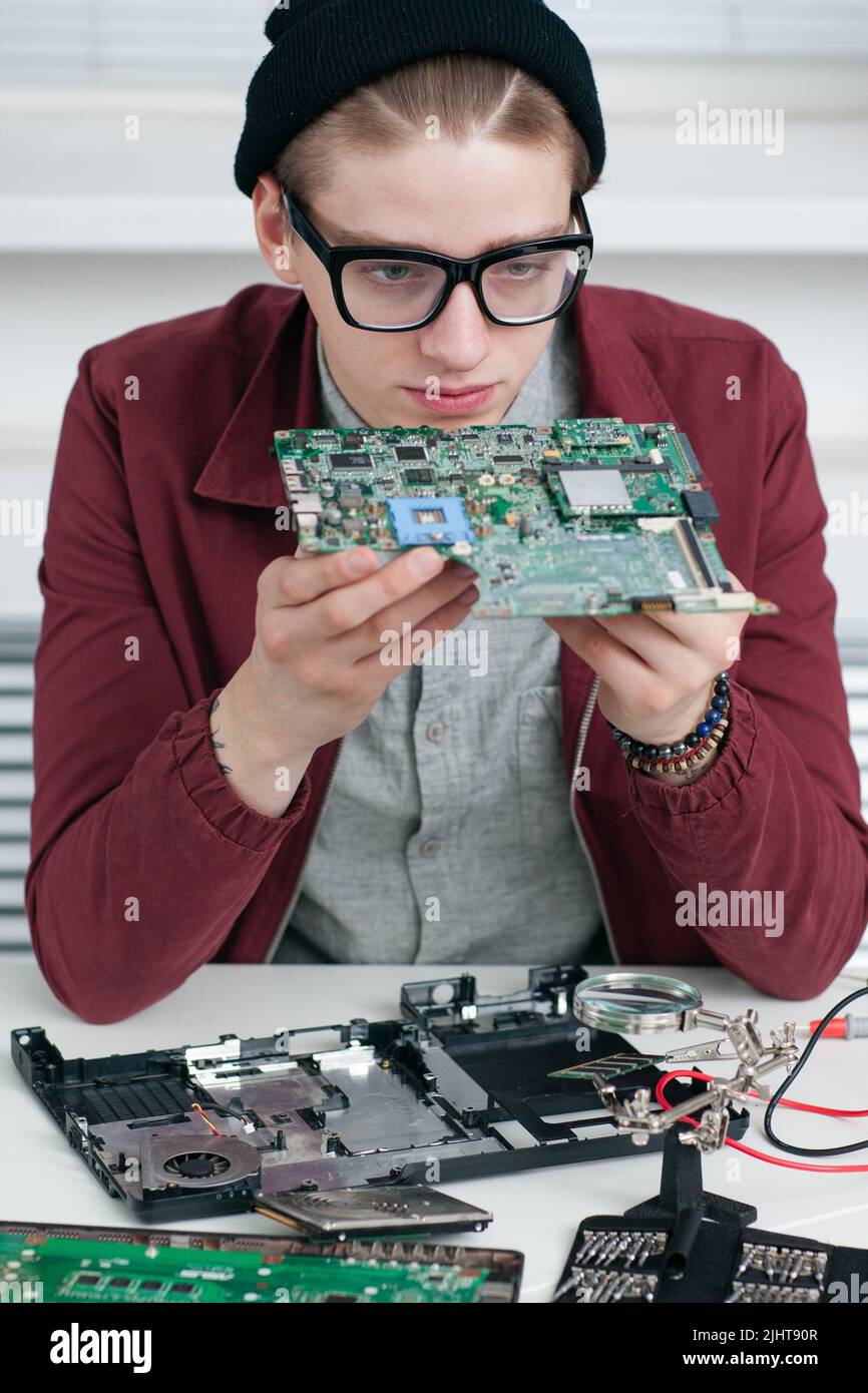 Programmatore che studia CPU guasta in officina Foto Stock
