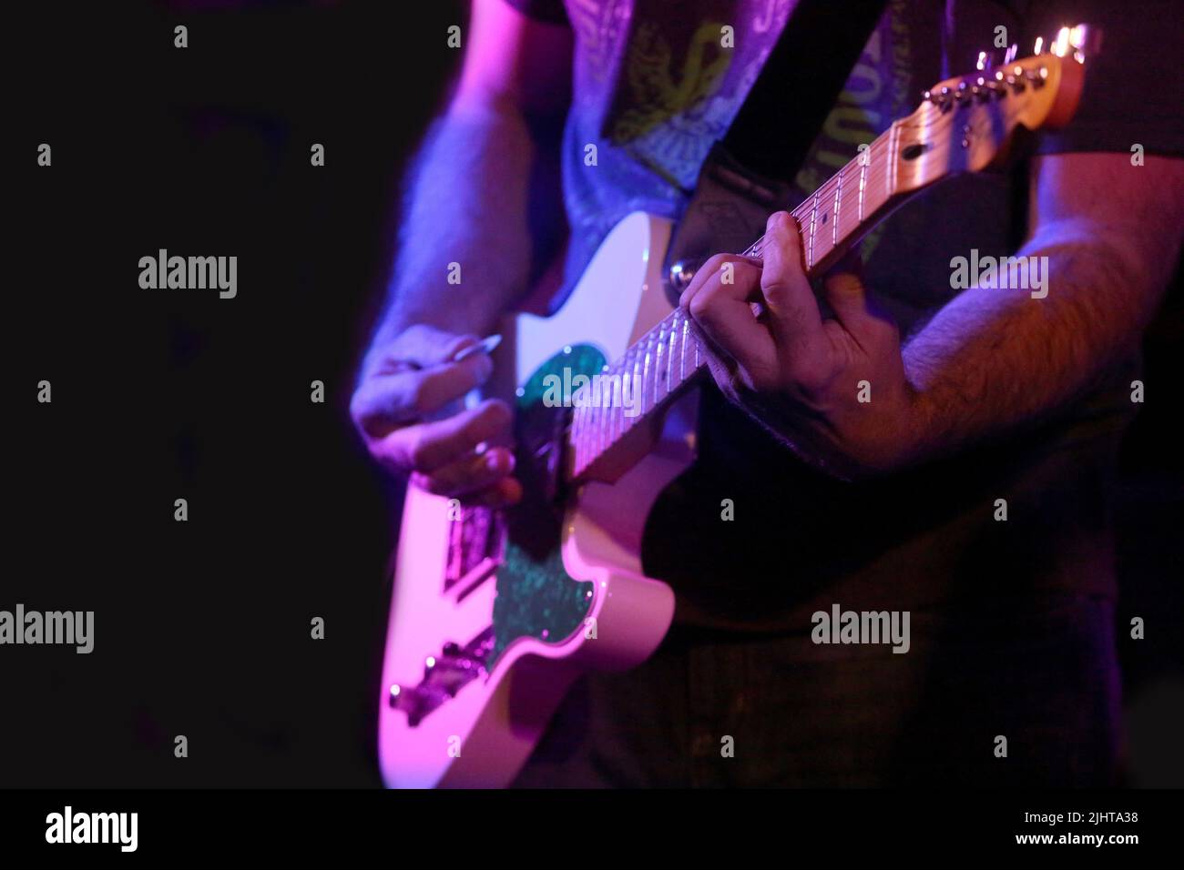 Un chitarrista inforta i tasti su una chitarra elettrica. Foto Stock