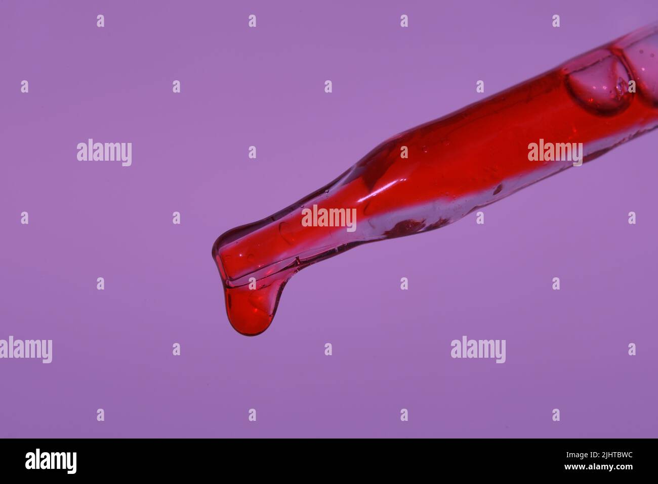 Pipettare con una goccia di sangue sullo sfondo del colore dell'anno 2022. Sangue per preparazioni iniettabili, plasmoliazione. Procedura cosmetica per la pelle del viso utilizzando sangue. Foto di alta qualità Foto Stock