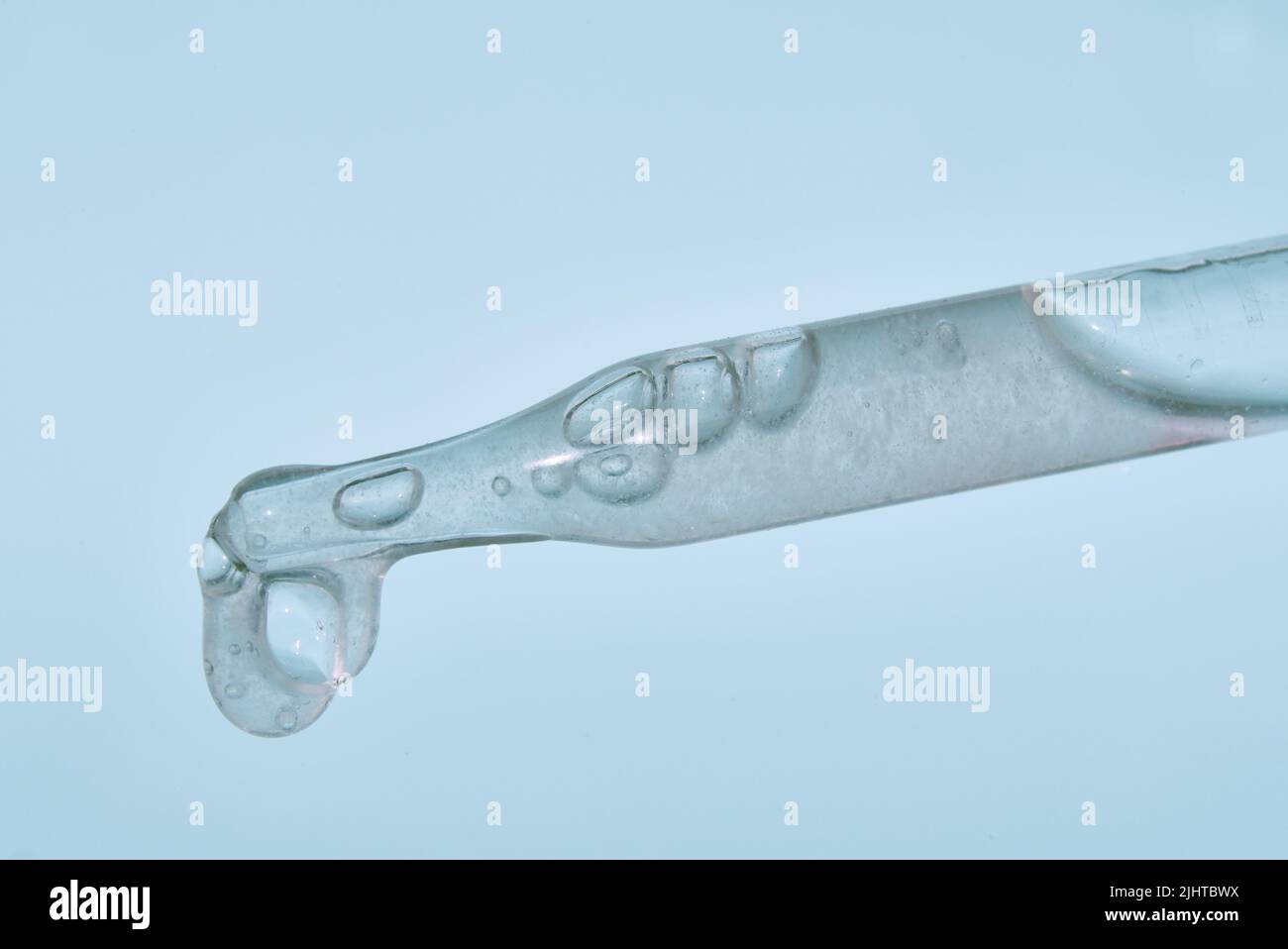 Pipettare con l'estratto su sfondo blu. Eccellente consistenza, polpa di aloe. Il concetto di estratto vegetale per scopi cosmetici e terapeutici. Foto di alta qualità Foto Stock