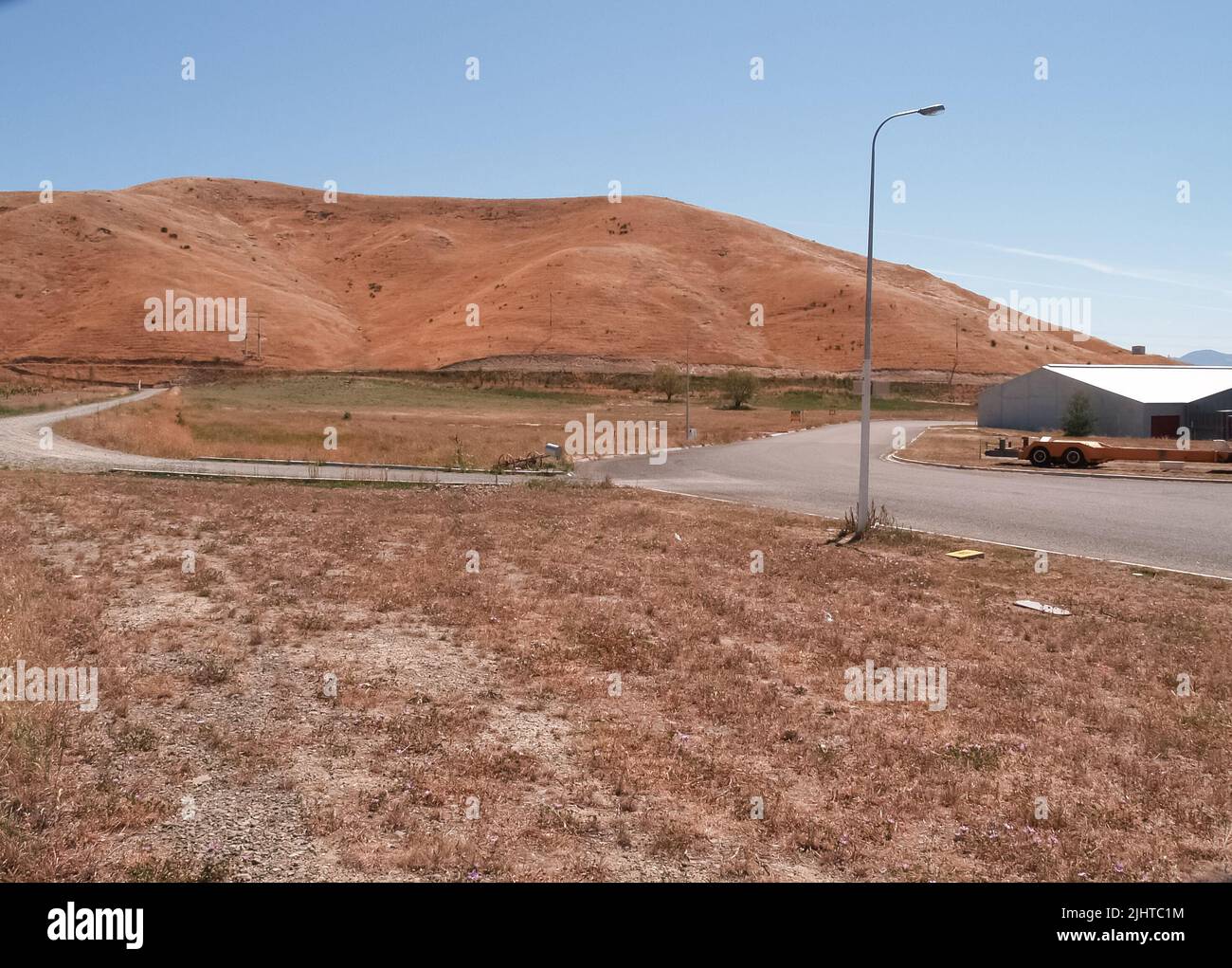 Nuovi terreni industriali in estate siccità colori suddivisi e roaded in attesa di sviluppo di nuovi edifici sotto il cielo blu. Foto Stock