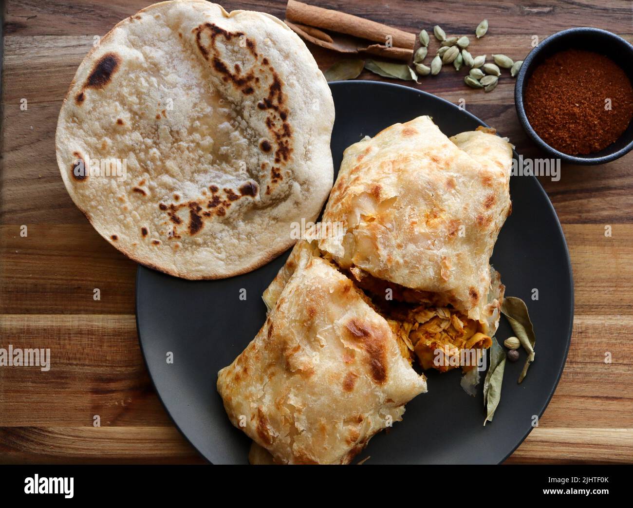 Roti al curry di pollo o salomie. Cibo tradizionale, un roti salomie ripieno di curry Foto Stock