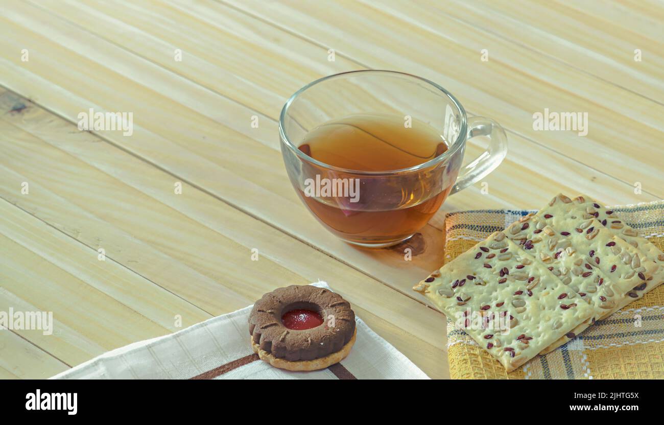 Una tazza di tè con diversi tipi di biscotti sul tavolo Foto Stock
