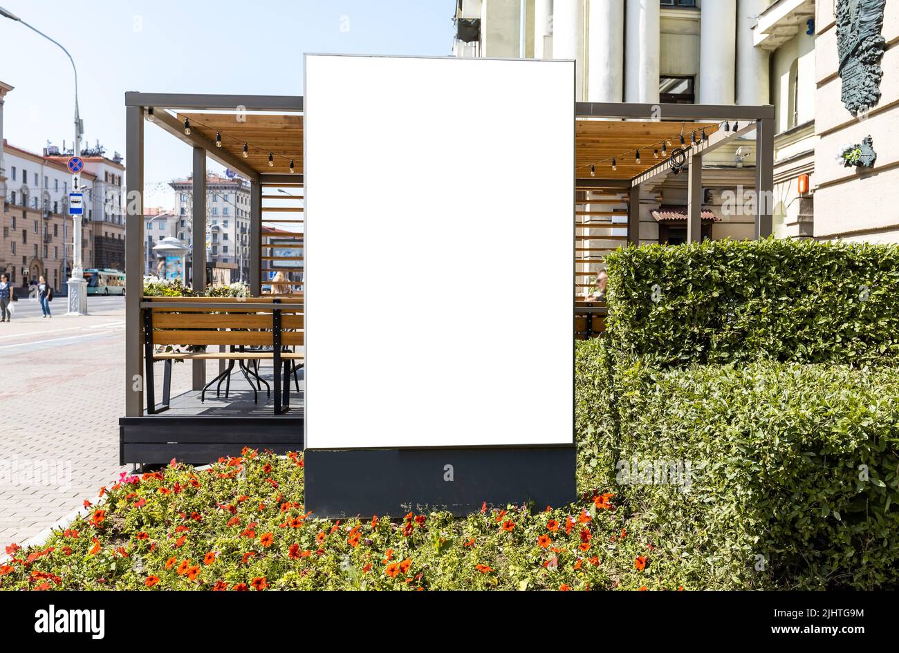 Grande mockup per affissioni vicino alla caffetteria sul marciapiede della città. Poster pubblicitari all'aperto per promuovere il ristorante o smth altrimenti situato in luogo storico bello con i fiori. Foto di alta qualità Foto Stock