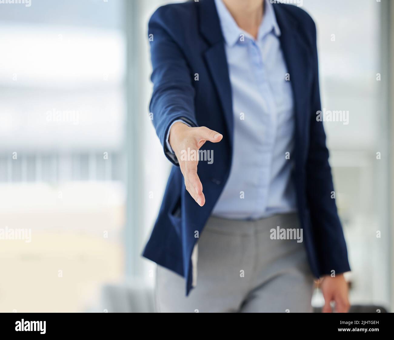 Primo piano della donna d'affari caucasica che si estende la mano in avanti per salutare il benvenuto con stretta di mano. Networking e riunione per concordare su trattativa o offerta Foto Stock