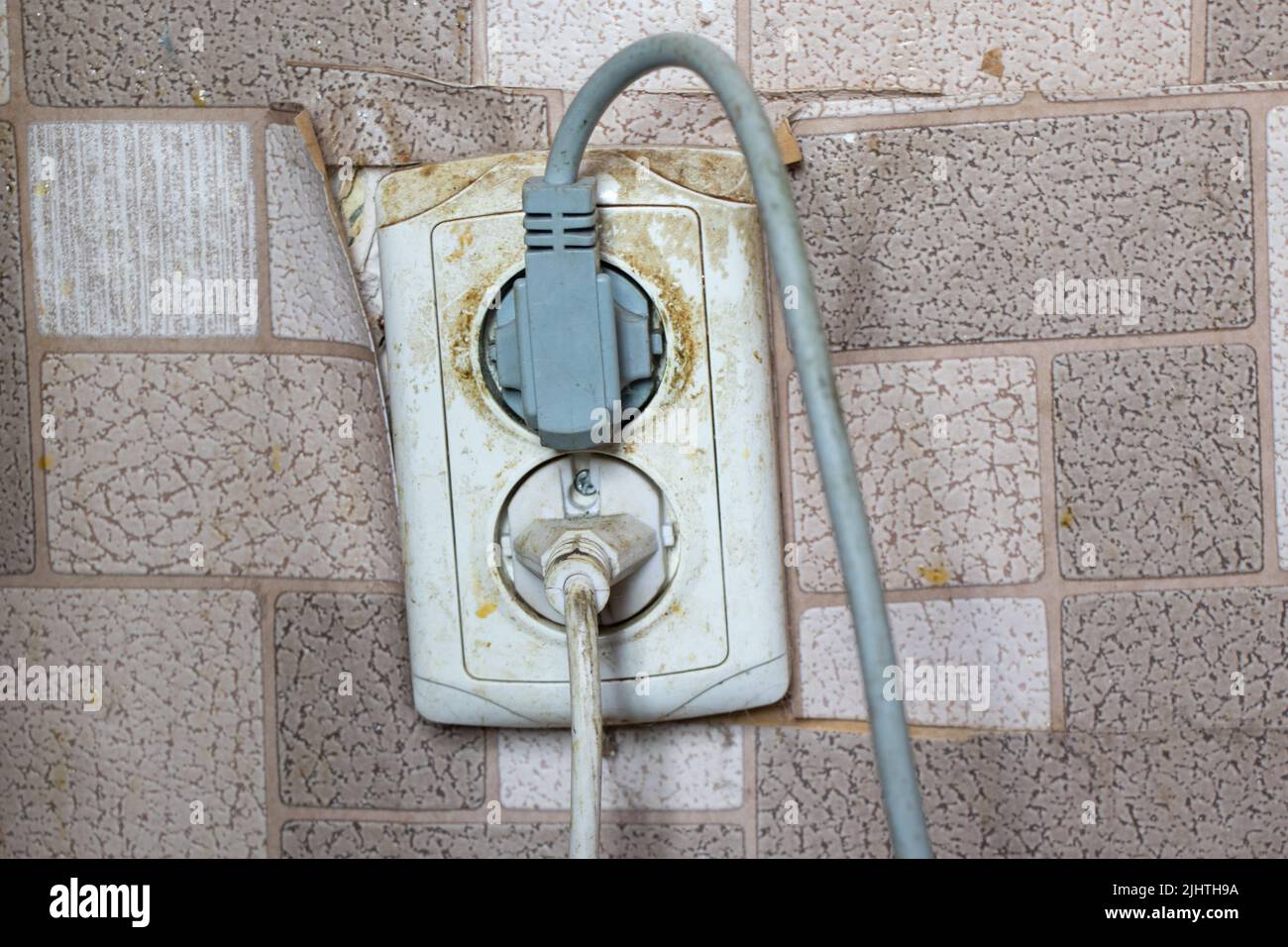 vecchia presa sporca nell'appartamento, presa pericolosa sulla parete da vicino Foto Stock