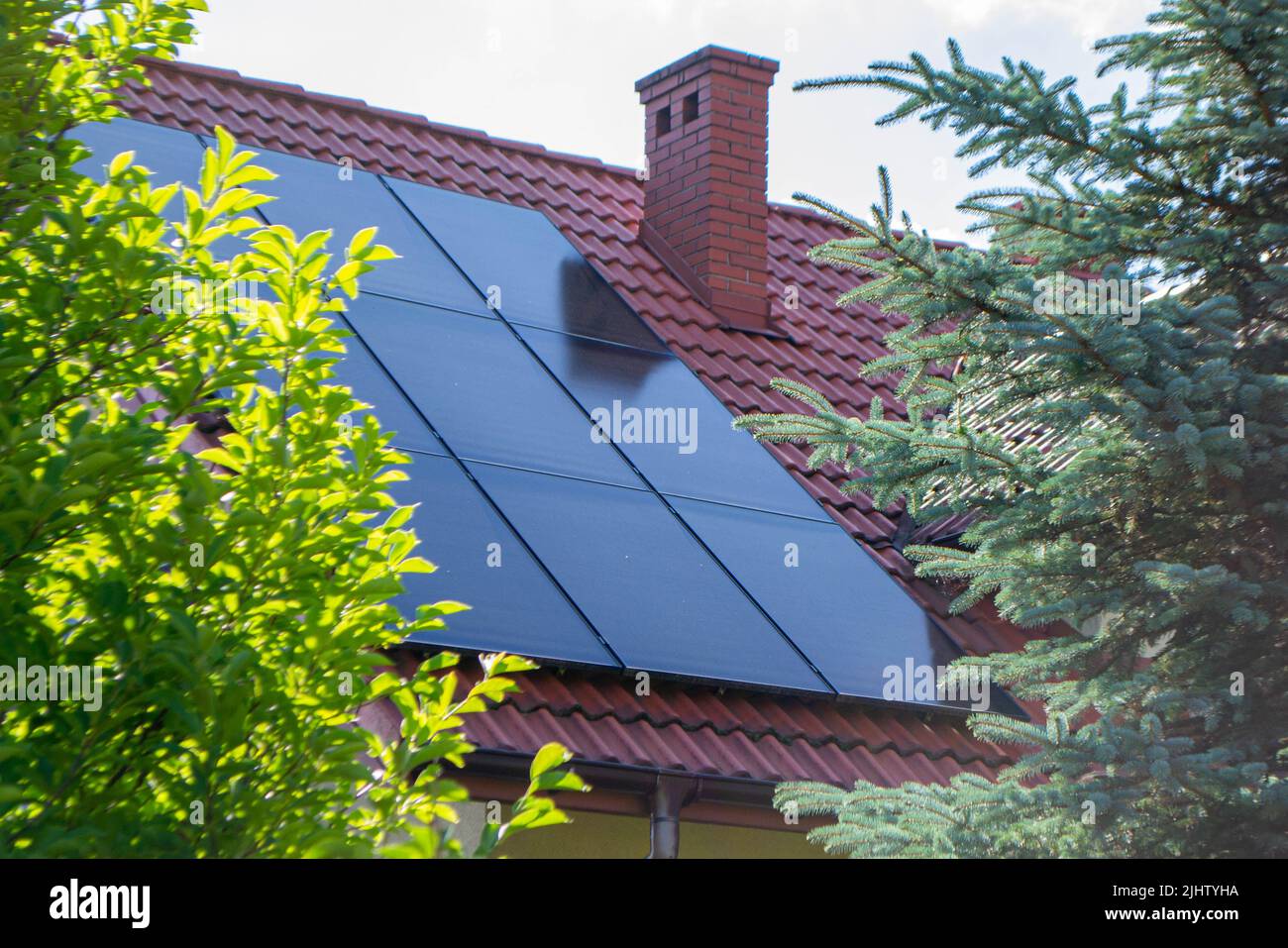 Tetto della casa con moduli fotovoltaici. Fattoria storica con pannelli solari moderni sul tetto e sulle pareti Foto di alta qualità Foto Stock