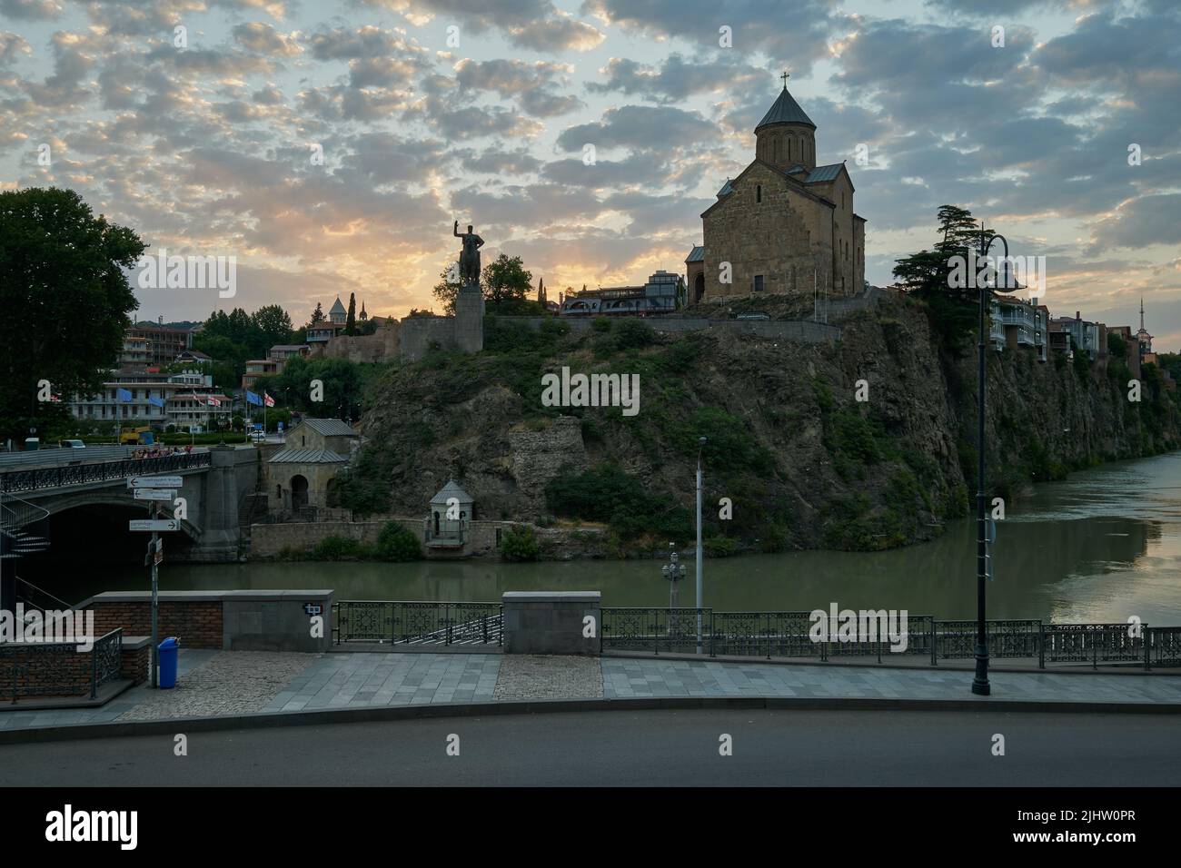 Metekhi Chiesa della Natività della Vergine Maria e il Monumento del Re Vakhtang Gorgasali in Tbilisi Vecchia vista al tramonto con le nuvole nel cielo Foto Stock