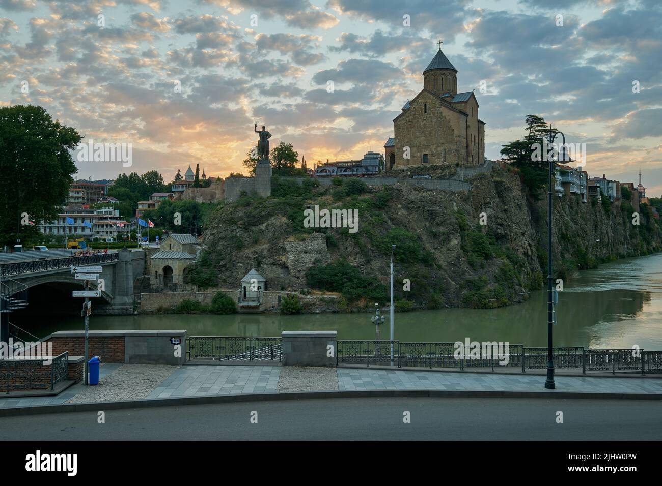 Metekhi Chiesa della Natività della Vergine Maria e il Monumento del Re Vakhtang Gorgasali in Tbilisi Vecchia vista al tramonto con le nuvole nel cielo Foto Stock