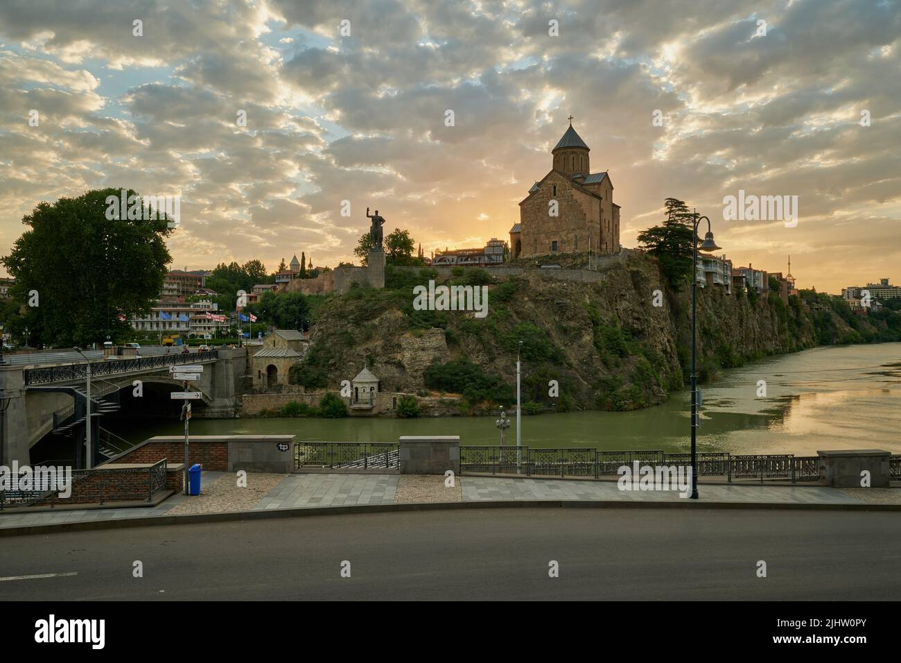 Metekhi Chiesa della Natività della Vergine Maria e il Monumento del Re Vakhtang Gorgasali in Tbilisi Vecchia vista al tramonto con le nuvole nel cielo Foto Stock