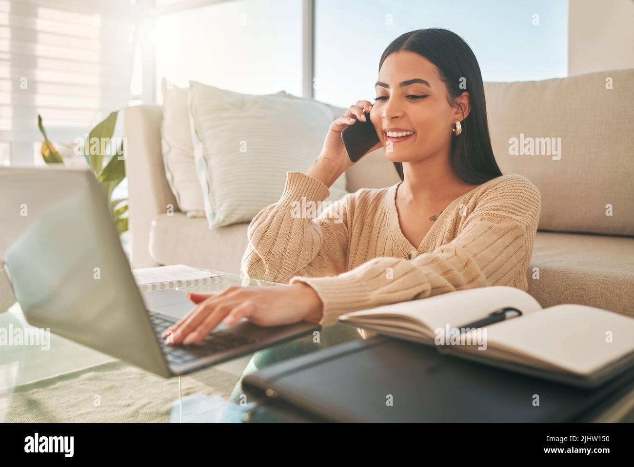 Grazie per avermi chiamato indietro. Una giovane donna attraente che parla al telefono mentre si rilassa a casa. Foto Stock