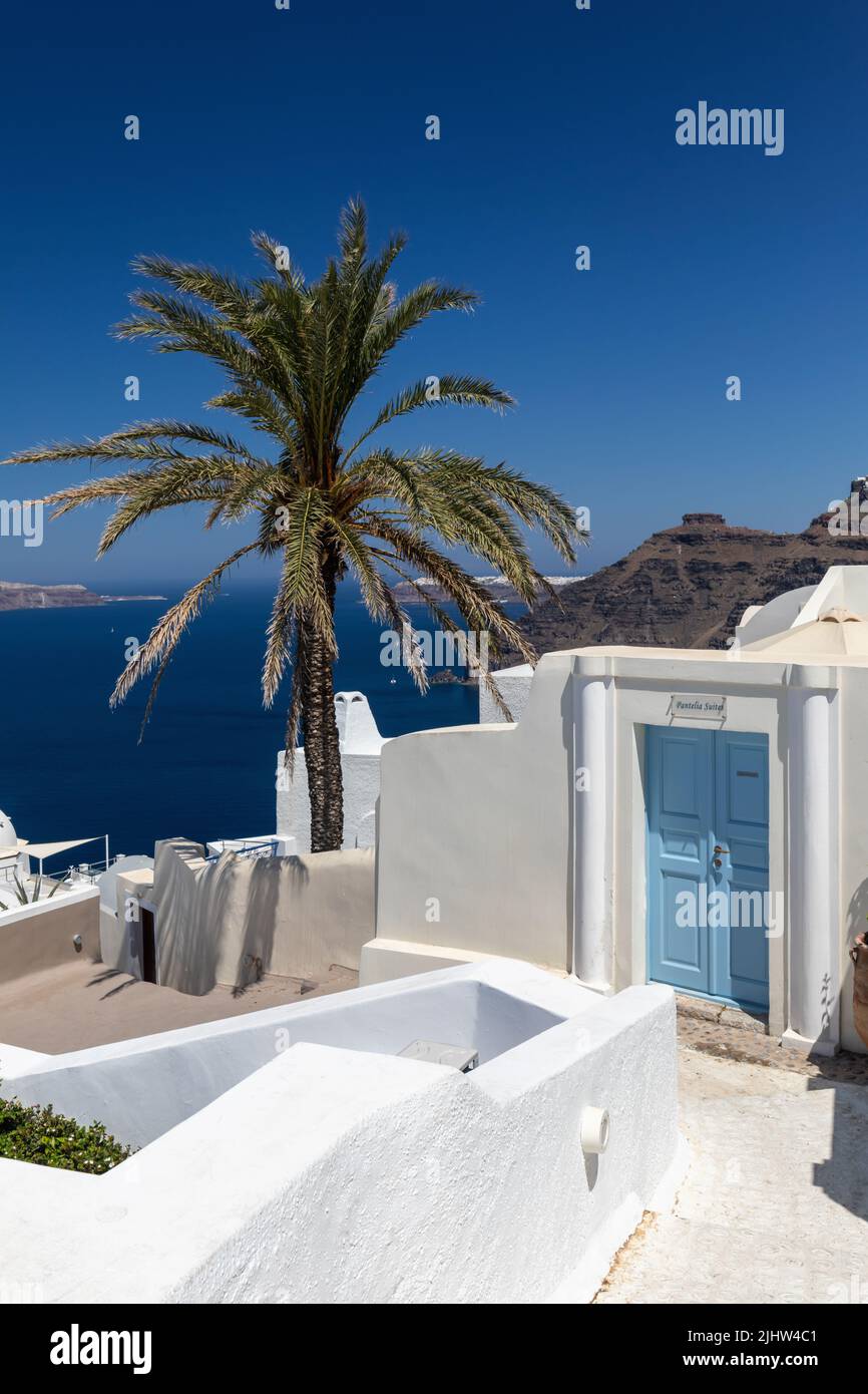 Pittoresca porta blu del Pantelia Suites Fira, con i suoi dintorni bianchi sulla caldera di Santorini. Vista sul Mar Egeo, Santorini, Cicladi, Grecia Foto Stock