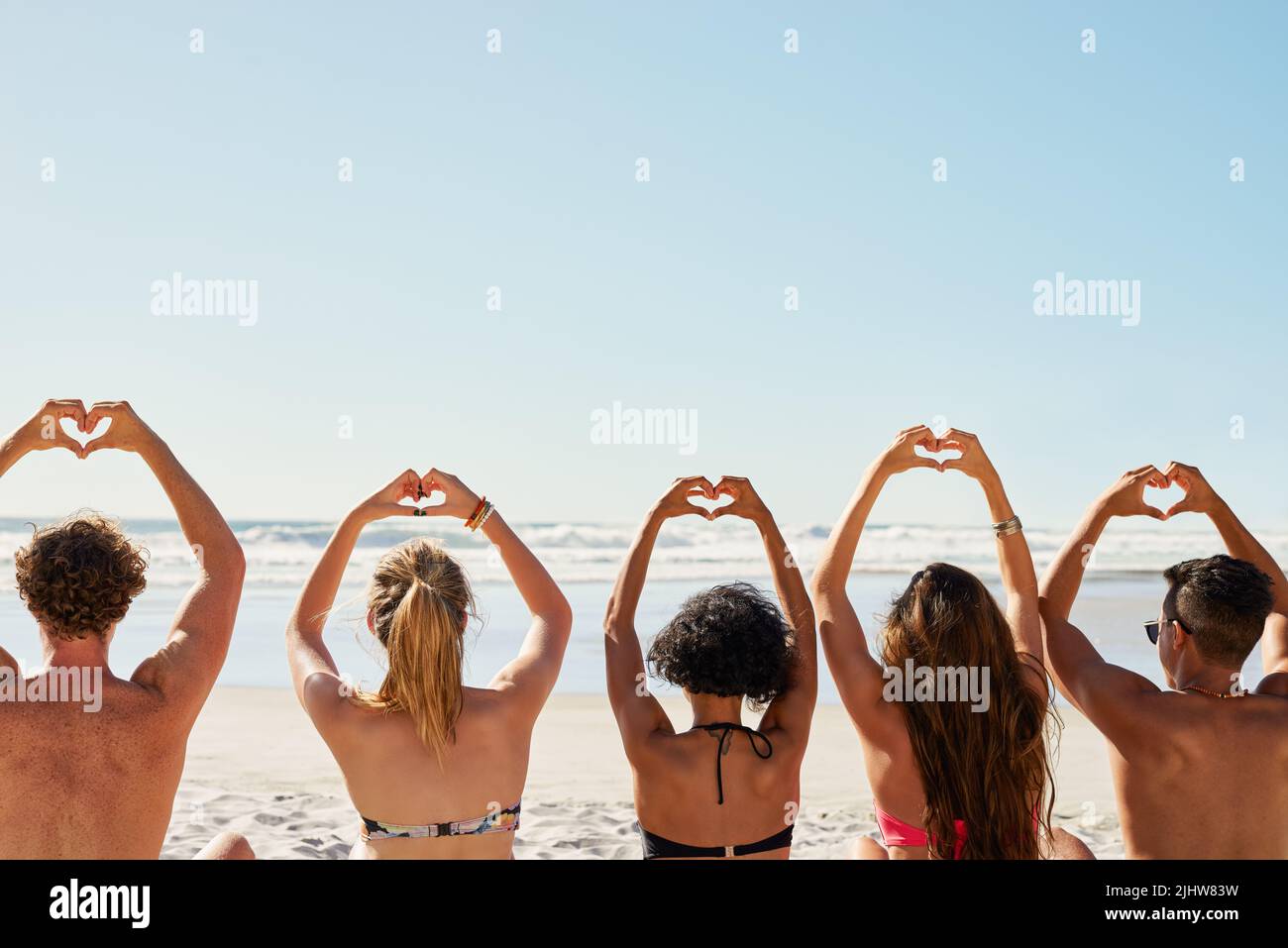 Diffonde l'amore ovunque tu vada. Un gruppo di amici con le mani nell'aria che creano forme di cuore. Foto Stock