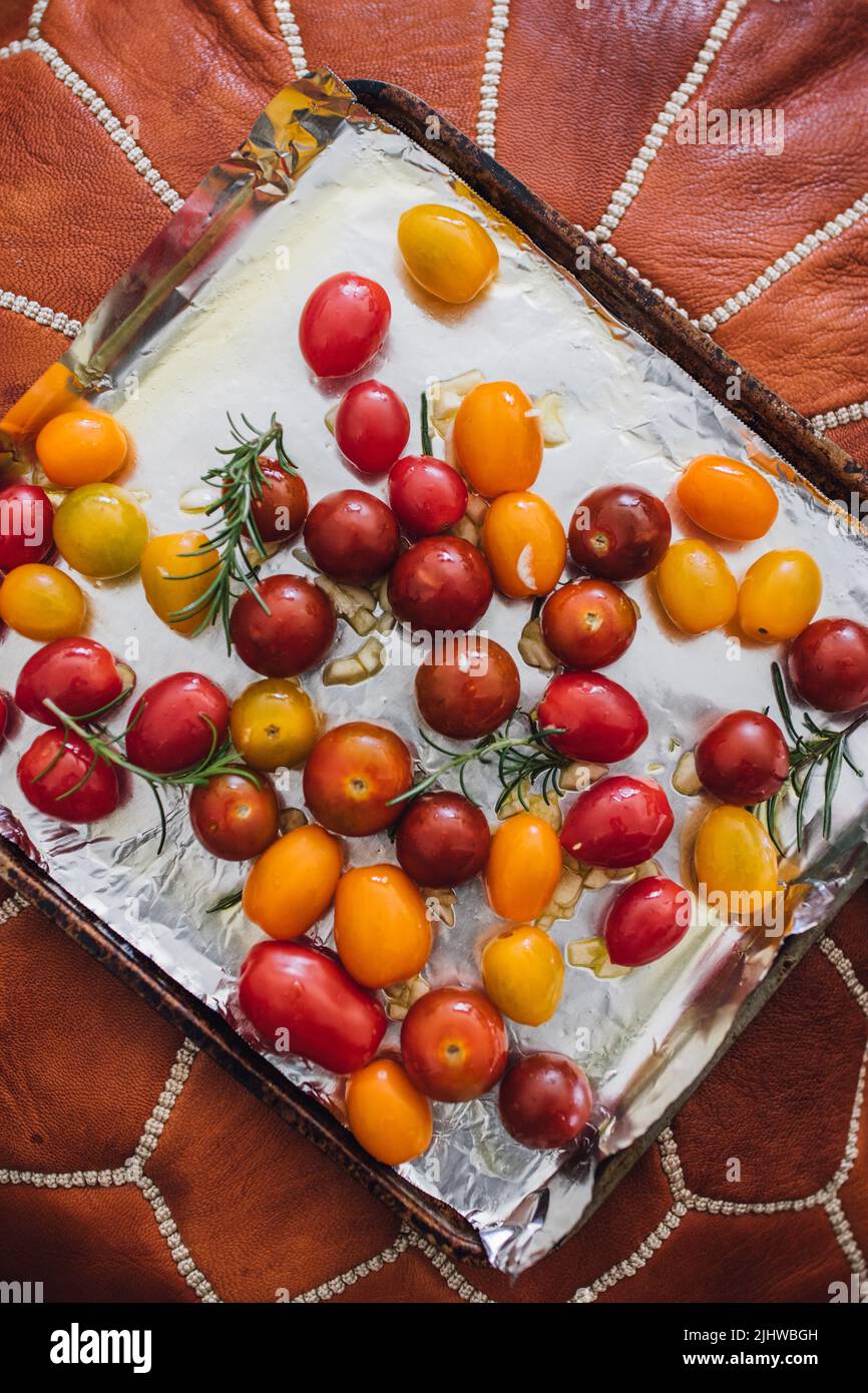 pomodori rossi, gialli, a ciliegia d'arancia per tostatura al rosmarino Foto Stock