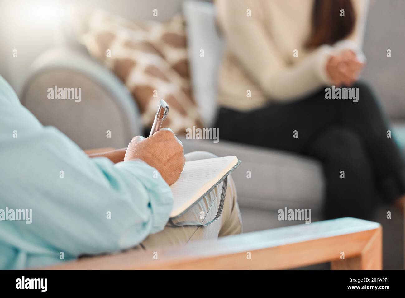 La terapia è parte integrante del campo della medicina, uno psicologo che prende appunti durante una consultazione. Foto Stock