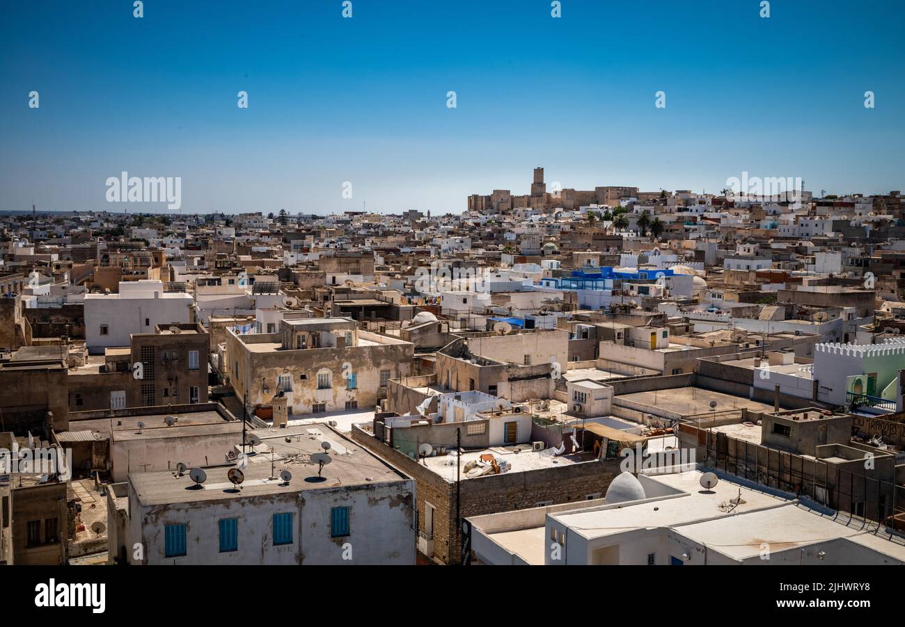 Una vista attraverso i tetti dell'antica Medina di Sousse in Tunisia verso la Kasbah di Sousse e il suo faro che domina lo skyline. Foto Stock