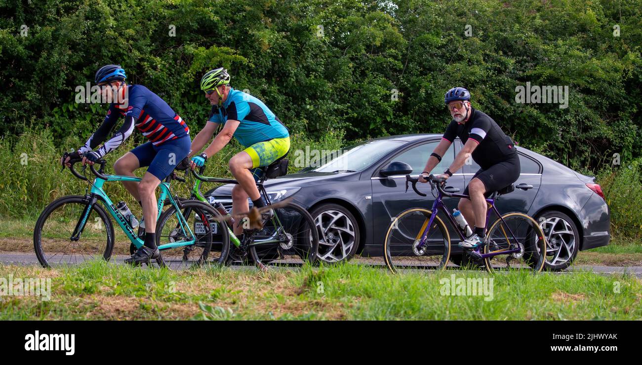 Gruppo di ciclisti passati da un'auto Foto Stock