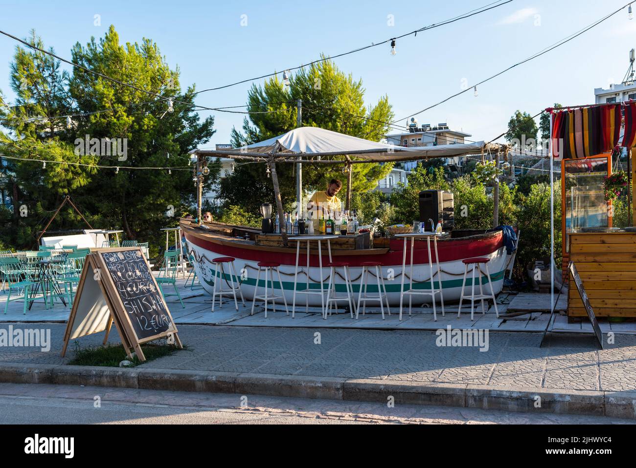 Ksamil, Albania - 9 settembre 2021: Vista sulla strada di Ksamil al giorno con il Boat-Bar a Ksamil, Albania. Foto Stock