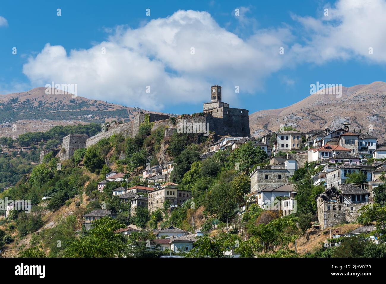 Gjirokaster, Albania - 10 settembre 2022: Paesaggio con un castello di Gjirokaster e torre dell'orologio con case ottomane sotto a Gjirokaster, Albania. Foto Stock