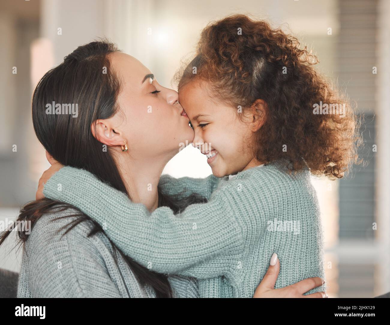 L'informalità della vita familiare è una condizione benedetta: Una madre e una figlia seduti sul divano a casa. Foto Stock