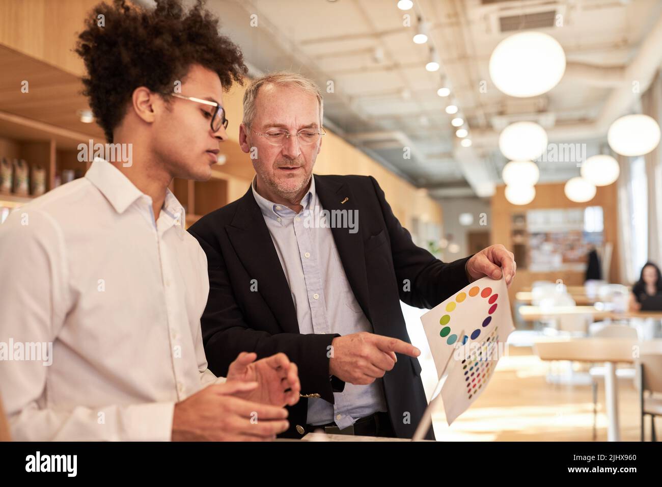 Manager con tavolozza di colori e designer creativo che sviluppa web design in ufficio Foto Stock