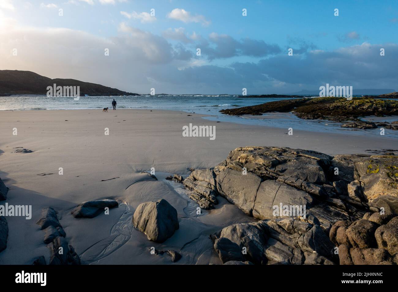 Paesaggio scozzese: Spiaggia di Bourblach vicino a Morar con escursionista solista e cane sulle sabbie, Scozia Foto Stock