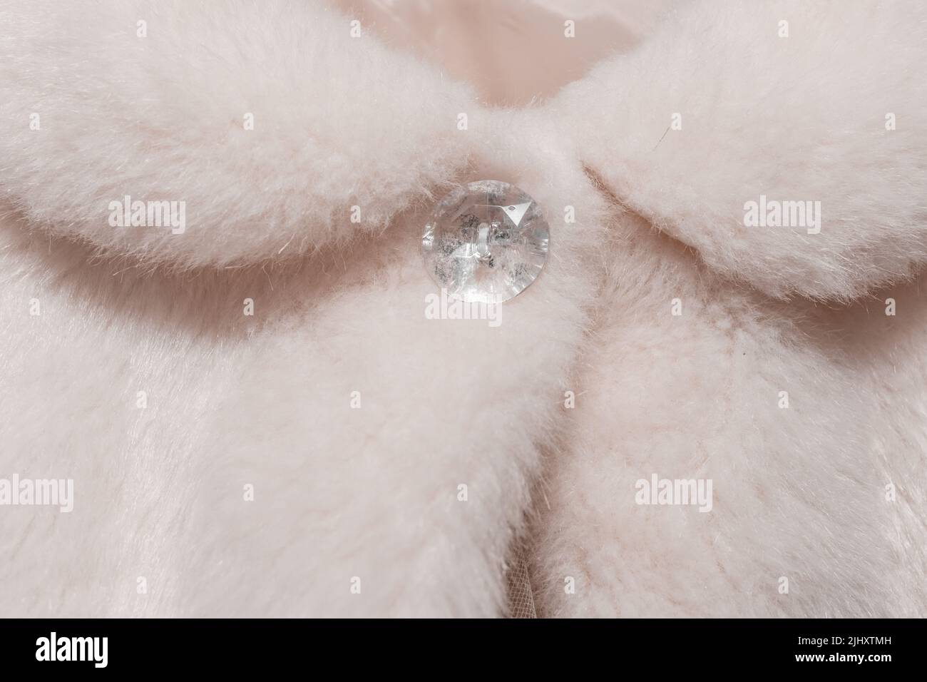 Clasp pulsante bianco donna su mantello fatto di pelliccia artificiale lana elemento di matrimonio frammento oggetto abiti da vicino della sposa. Foto Stock