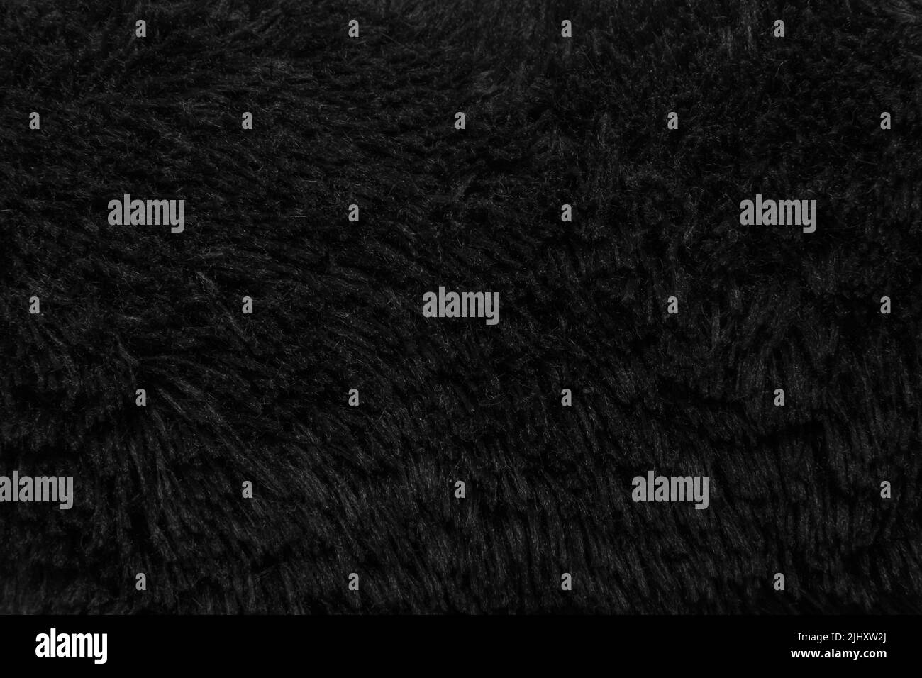 Faux pelliccia lana nera astratto motivo natura pelle morbida caldo soffice sfondo scuro artificio texture. Foto Stock