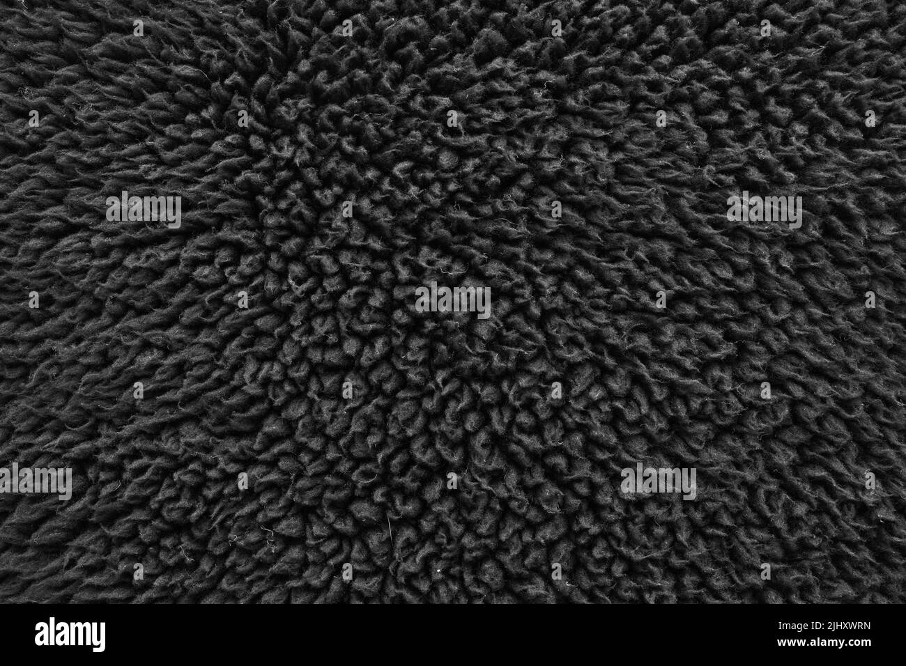 Faux pelliccia lana nera astratto motivo natura pelle morbida caldo soffice sfondo scuro artificio texture. Foto Stock
