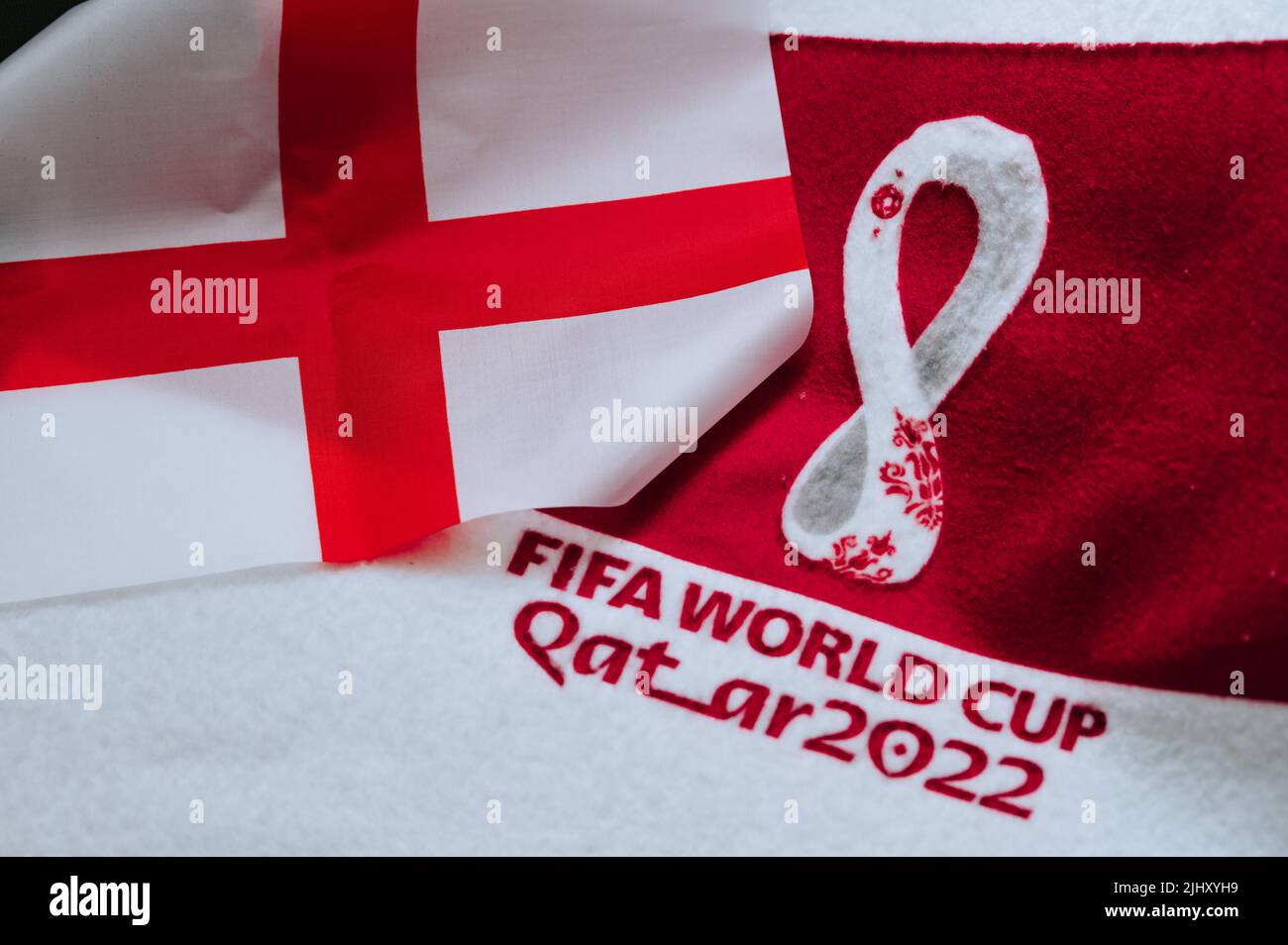 QATAR, DOHA, 18 LUGLIO 2022: Bandiera inglese nazionale e logo della Coppa del mondo FIFA Qatar 2022 su tappeto rosso. Sfondo dello sport di calcio, spazio di modifica. Qatar 2 Foto Stock