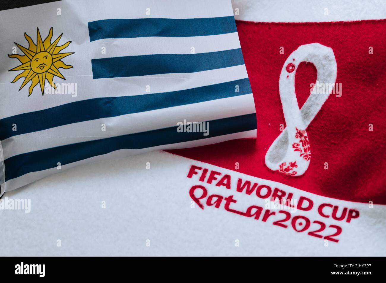 QATAR, DOHA, 18 LUGLIO 2022: Bandiera dell'Uruguay e logo della Coppa del mondo FIFA Qatar 2022 su tappeto rosso. Sfondo dello sport di calcio, spazio di modifica. Qatar 2 Foto Stock