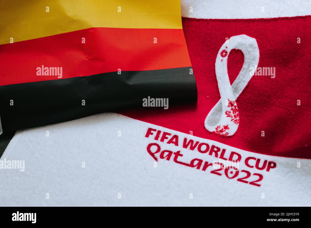 QATAR, DOHA, 18 LUGLIO 2022: Germania bandiera nazionale e logo della Coppa del mondo FIFA in Qatar 2022 su tappeto rosso. Sfondo dello sport di calcio, spazio di modifica. Qatar 2 Foto Stock