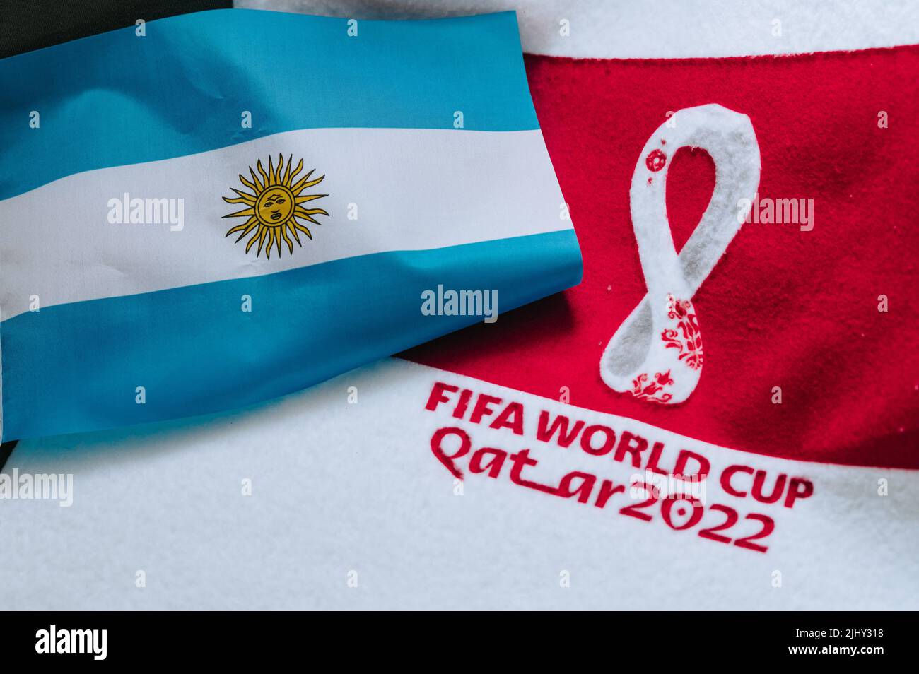 QATAR, DOHA, 18 LUGLIO 2022: Bandiera nazionale dell'Argentina e logo della Coppa del mondo FIFA in Qatar 2022 su tappeto rosso. Sfondo dello sport di calcio, spazio di modifica. Qatar Foto Stock