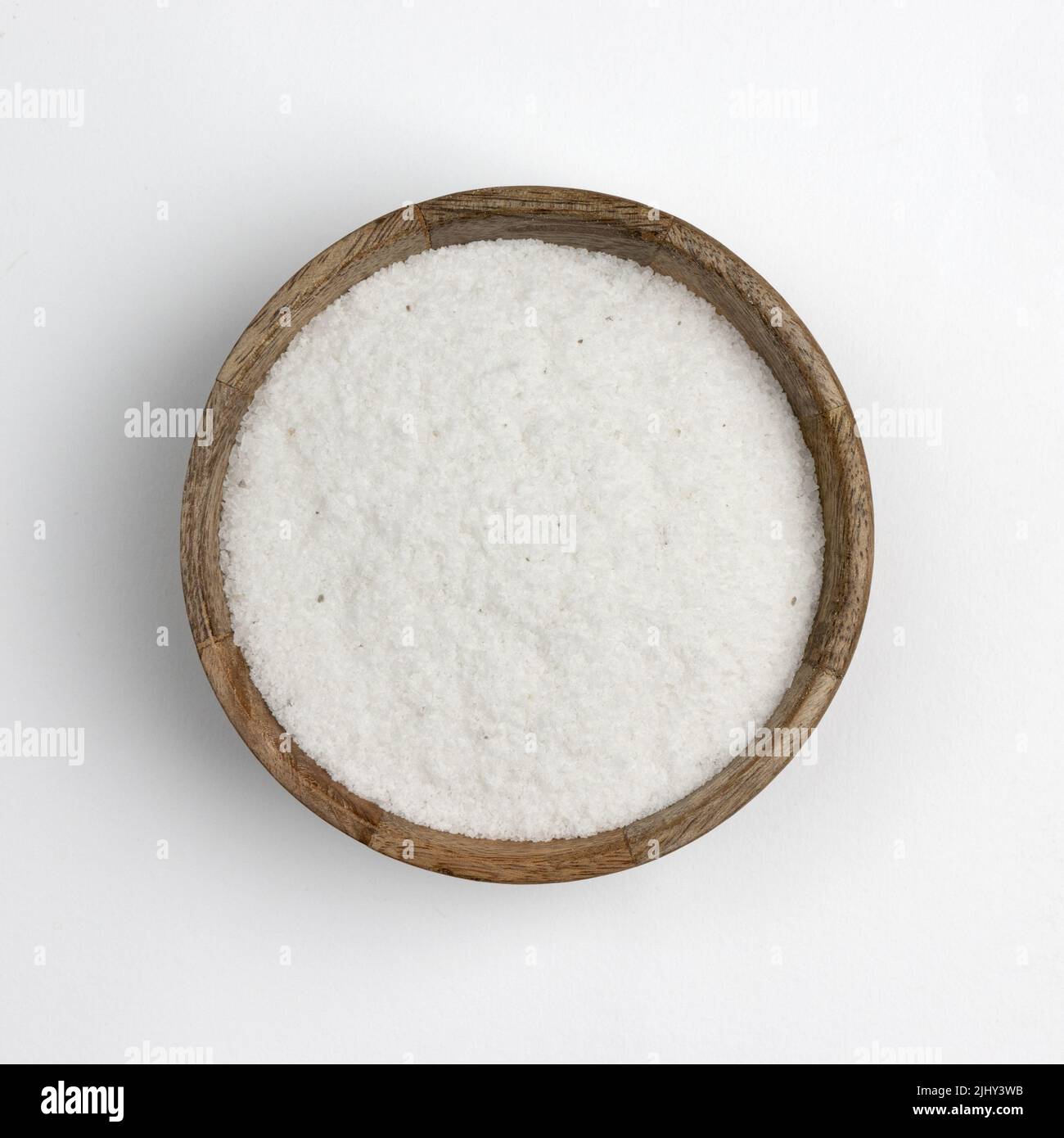 sale marino in ciotola di legno isolato su sfondo bianco, prodotto minerale utilizzato in cucina e cosmetici, macro foto di condimento, primo piano Foto Stock