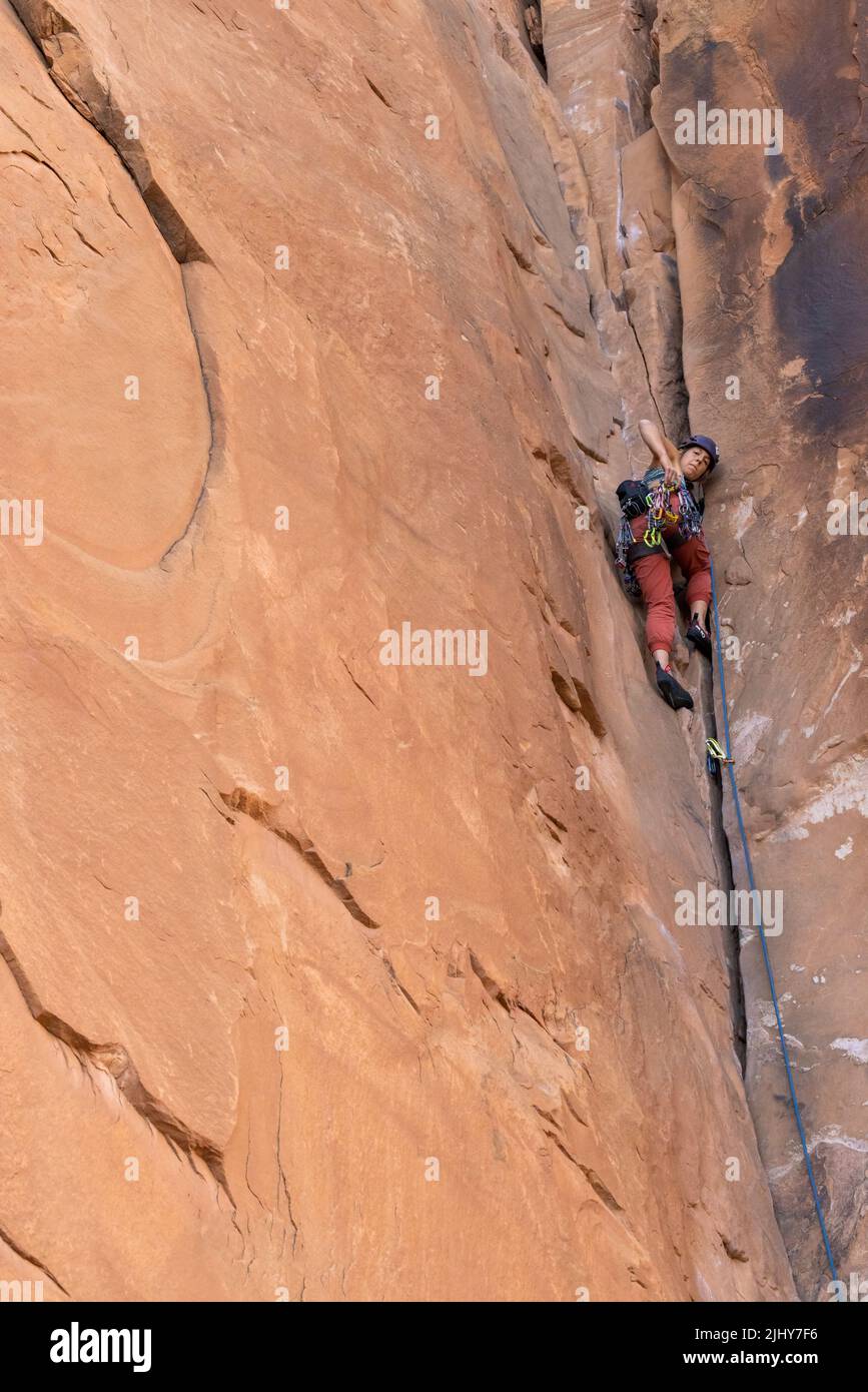Arrampicata femminile su roccia arenaria vicino a Moab, Utah Foto Stock