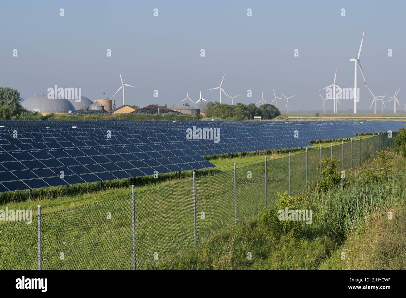 GERMANIA, impianto di Biogas e campo solare di GP Joule, dietro turbine eoliche / DEUTSCHLAND, Schleswig-Holstein, Reußenkoog, GP Joule Biogasanlage und Photovoltaik Anlage, Windkraftanlagen im Hintergrund Foto Stock