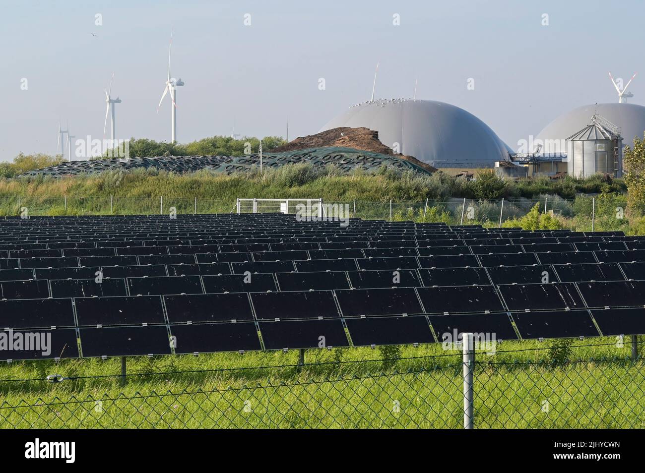 GERMANIA, impianto di Biogas e campo solare di GP Joule, dietro turbine eoliche / DEUTSCHLAND, Schleswig-Holstein, Reußenkoog, GP Joule Biogasanlage und Photovoltaik Anlage, Windkraftanlagen im Hintergrund Foto Stock