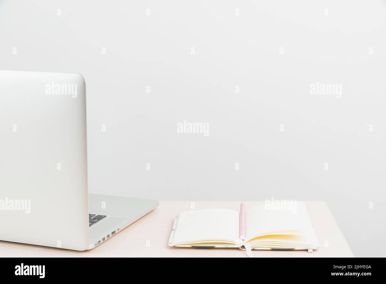 Un'area di lavoro ordinata con strumenti da scrivania e un computer portatile con spazio per la copia Foto Stock