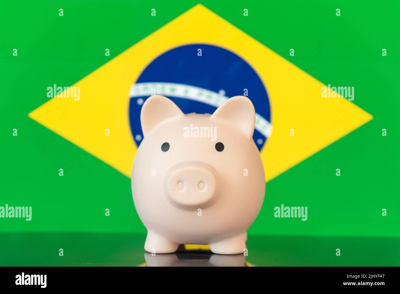 Piggy banca con bandiera nazionale del Brasile. Concetto di crisi finanziaria e risparmiare denaro Foto Stock