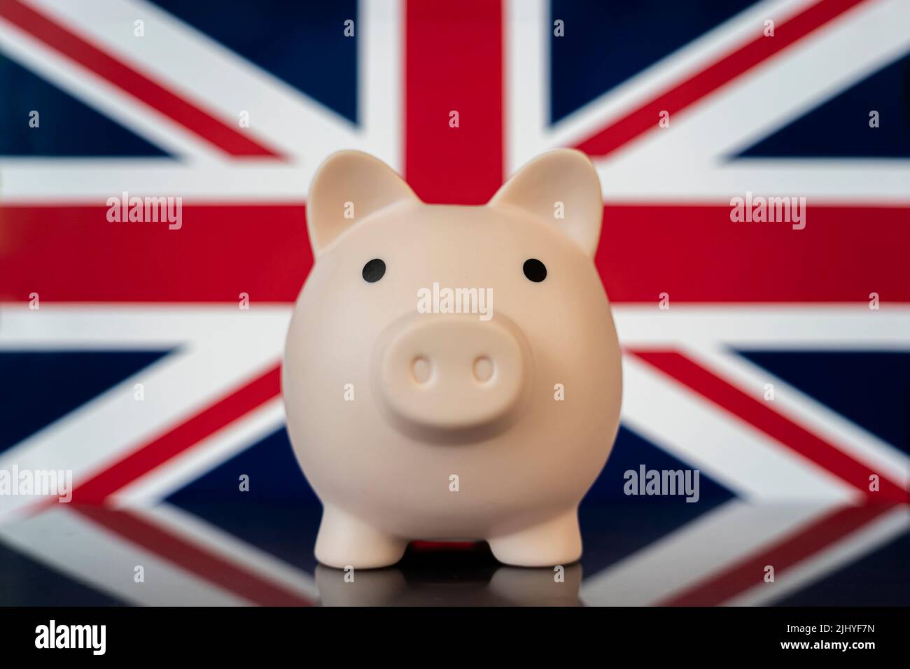Concetto di economia del Regno Unito. Rosa Piggy banca sulla bandiera britannica primo piano. Concetto di crisi finanziaria e risparmiare denaro Foto Stock