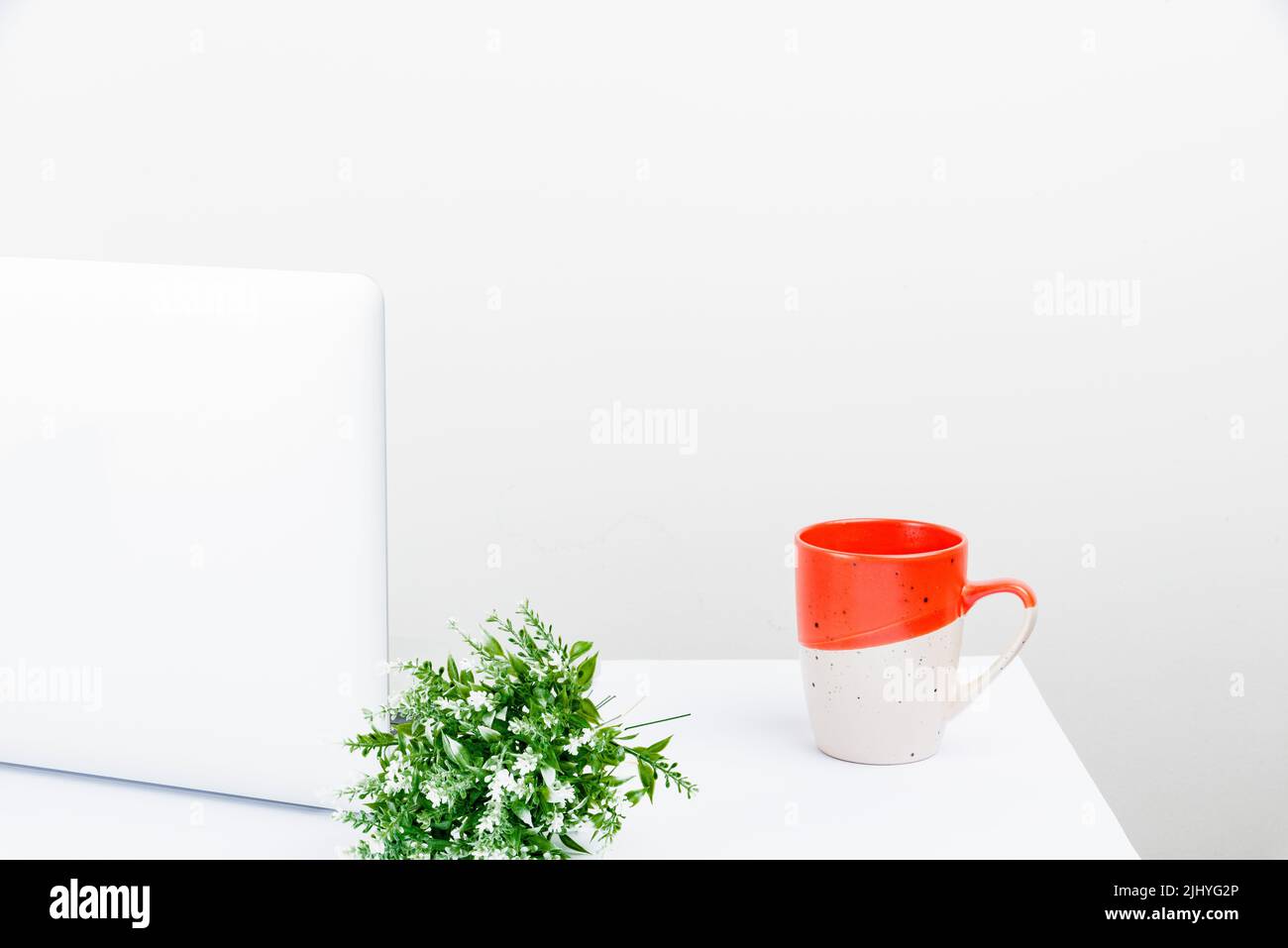 Un'area di lavoro ordinata con strumenti da scrivania e un computer portatile con spazio per la copia Foto Stock
