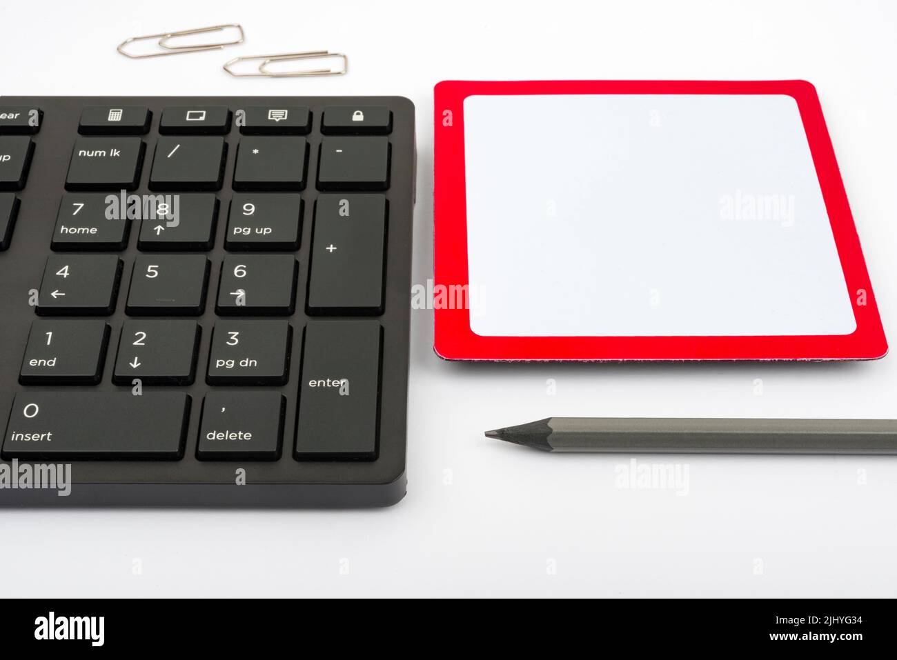Una tastiera per computer, una matita e clip su un tavolo Foto Stock