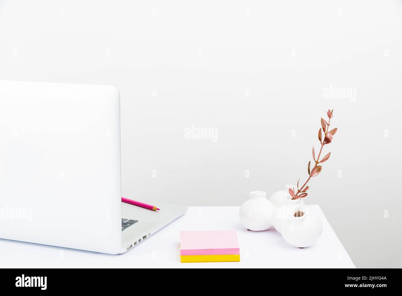 Una configurazione ordinata dell'area di lavoro con un computer portatile bianco e fisso Foto Stock
