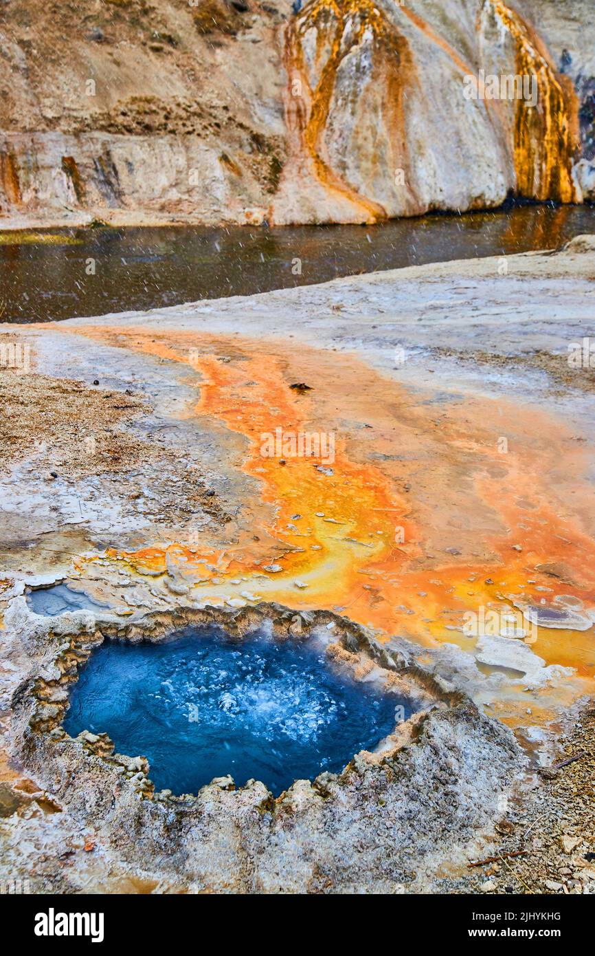 Vibrante cinese blu con sedimento arancione che scorre nel fiume a Yellowstone Foto Stock
