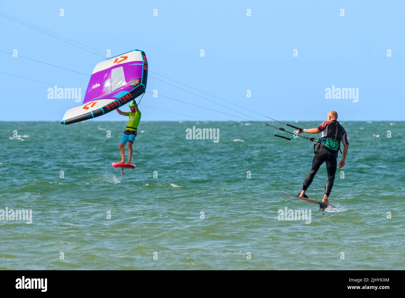 Kiteboarder / kitesurfer e wingboarder / ala boarder su foilboard / aliscafo surf con ala gonfiabile sul Mare del Nord Foto Stock