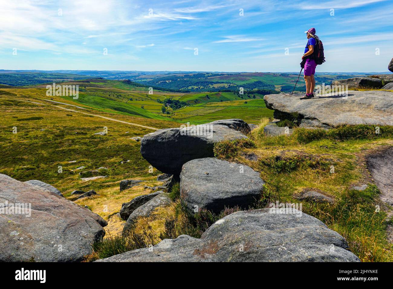 Escursionista femminile a Stanage Edge, Gritstone Cliff, Peak District National Park, Derbyshire, Regno Unito Foto Stock